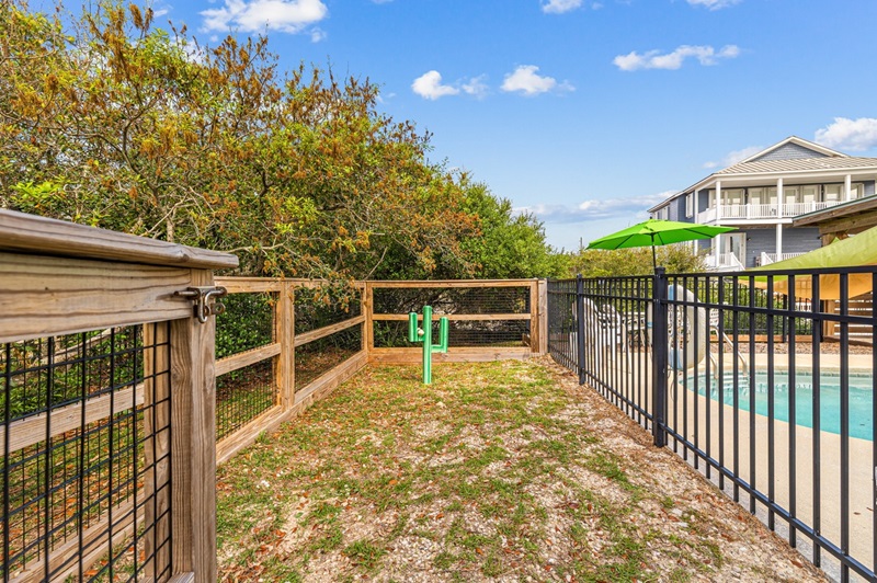 Fenced dog run next to a pool at Beach love and Happiness a St George Island Florida Rental that is Dog Friendly